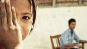 young nepali girl with hand over eye at eye screening