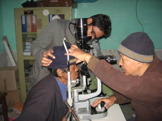 A nepali patient has his eyes examined by Seva using a slit lamp